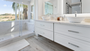 Spa-like modern bathroom in a Laguna Hills home listed by Claire Na, featuring a glass-enclosed walk-in shower, dual vanities, and serene hillside views.
