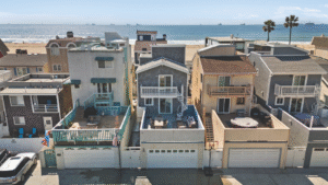 Aerial view of a beachfront home in Surfside, California, listed by Angela Caliger, showcasing ocean views and outdoor living spaces just steps from the sand.