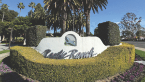 Entrance sign to Pacific Ranch community in Dana Point, California, surrounded by manicured landscaping and palm trees, with homes listed by Christina Vold and Jenna Constanzo.