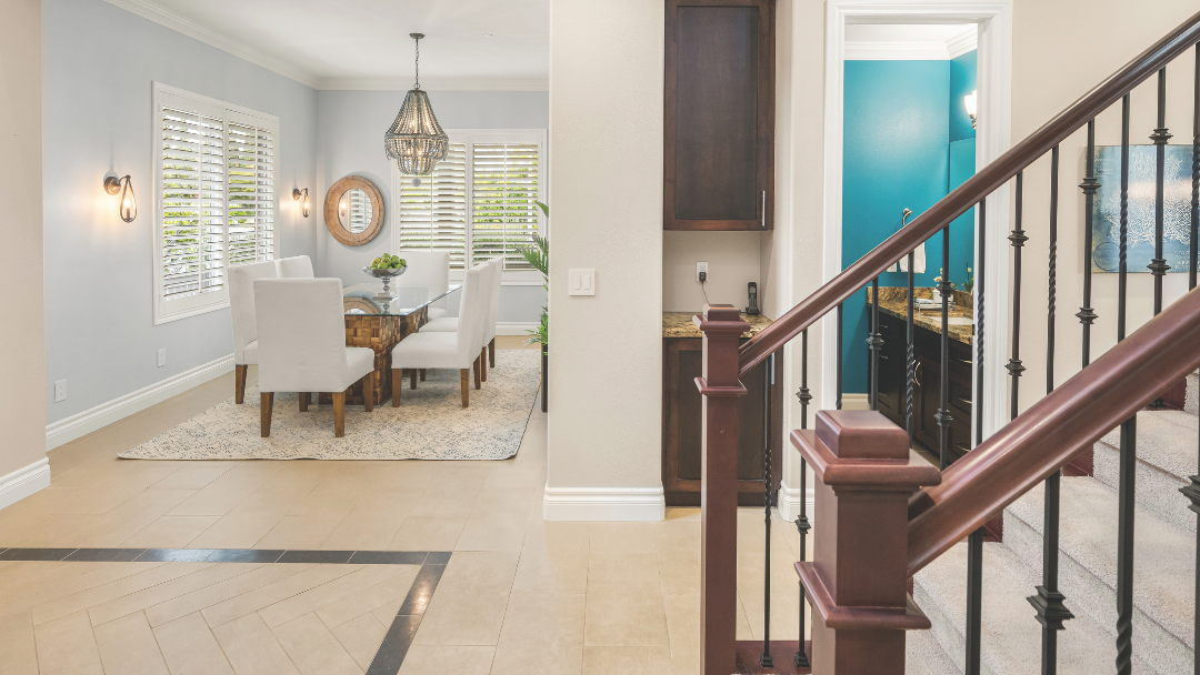 Elegant dining room and staircase interior in a Newport Beach home listed by Katie Rollins and Chris Moreno, featuring modern finishes and natural light.