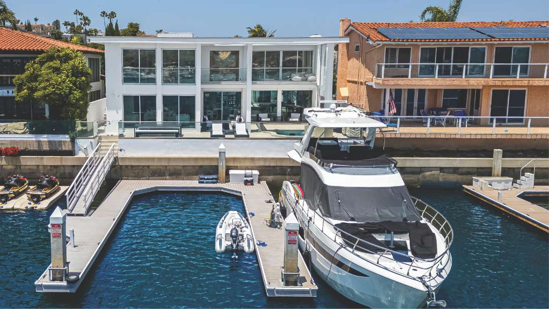 Modern waterfront home in Newport Beach with private dock and luxury yacht, listed by Angela Caliger.