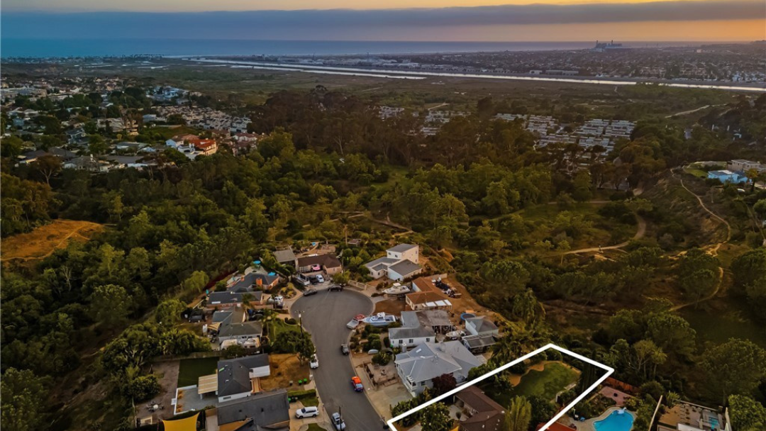 Aerial view of Costa Mesa cul-de-sac home bordering scenic nature trails at sunset