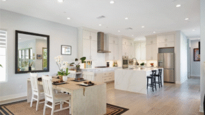 Bright modern kitchen and dining area with white cabinetry and recessed lighting in Irvine home