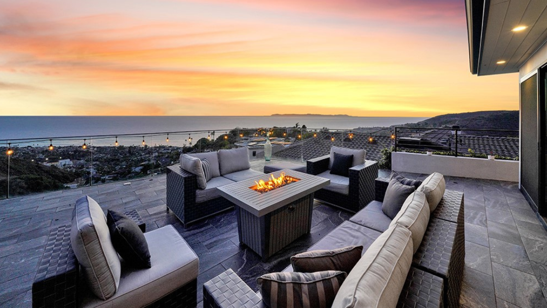 Luxury ocean-view terrace in Laguna Beach with fire pit seating at sunset