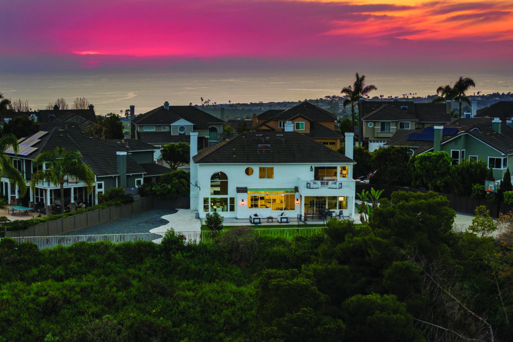 San Clemente hillside home with panoramic ocean views, backyard patio, and sunset sky