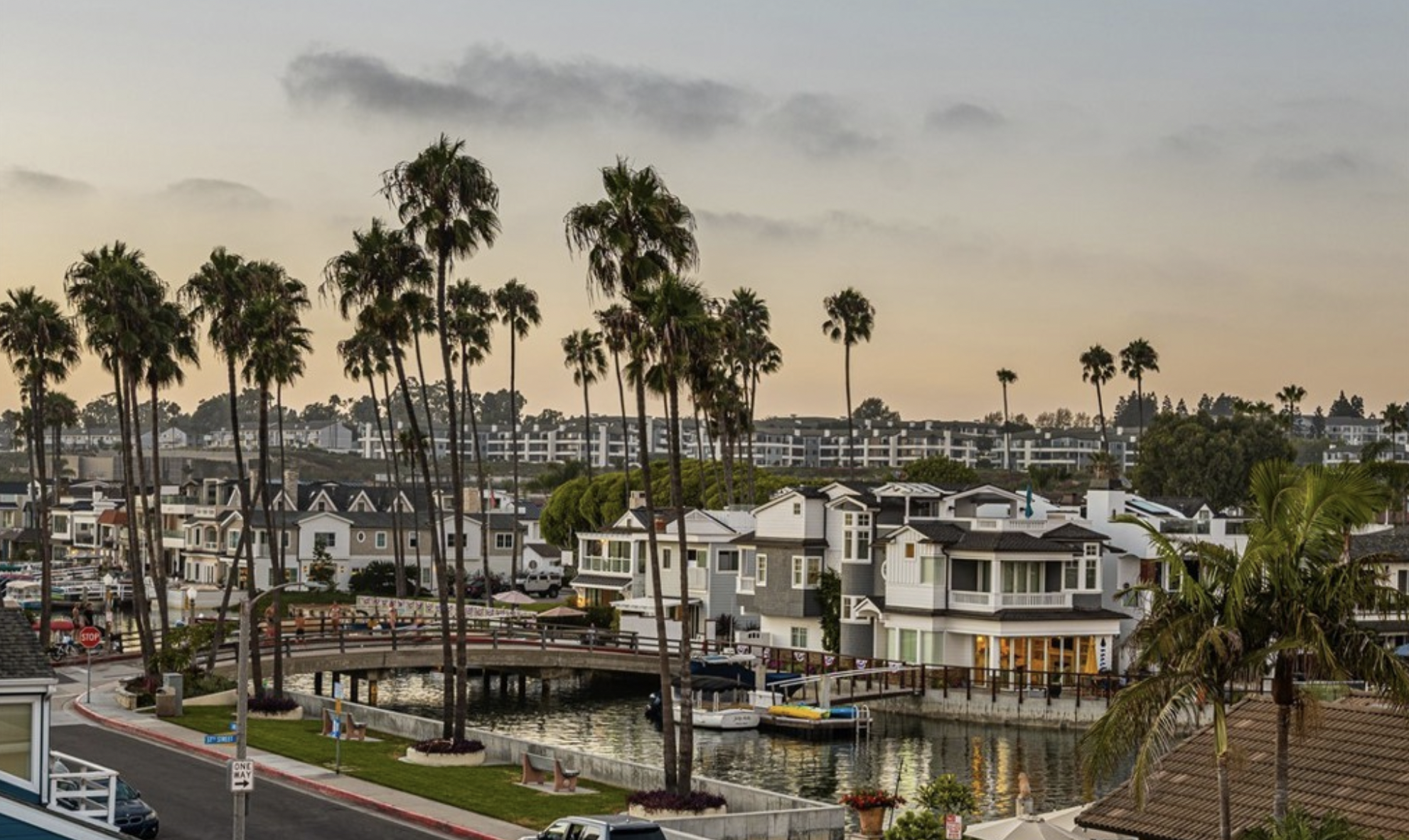 Waterfront home in Newport Beach, California, surrounded by palm trees and harbor views, listed by Chris Moreno and Cassie Hammond of Hammond Moreno Associates.