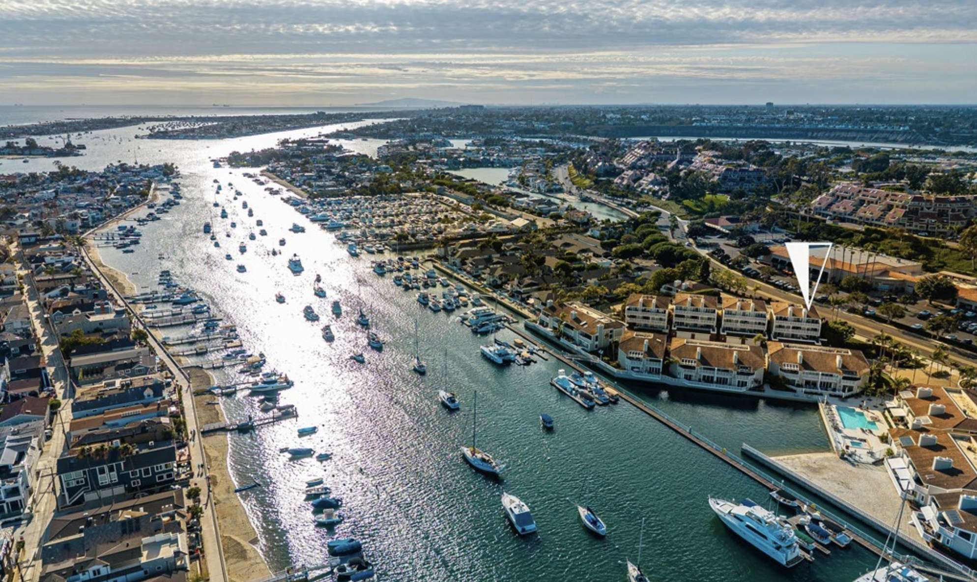 Aerial view of Newport Beach harbor and waterfront homes, highlighting a Newport Beach property listed by Eliisa Stowell and Mark Nix