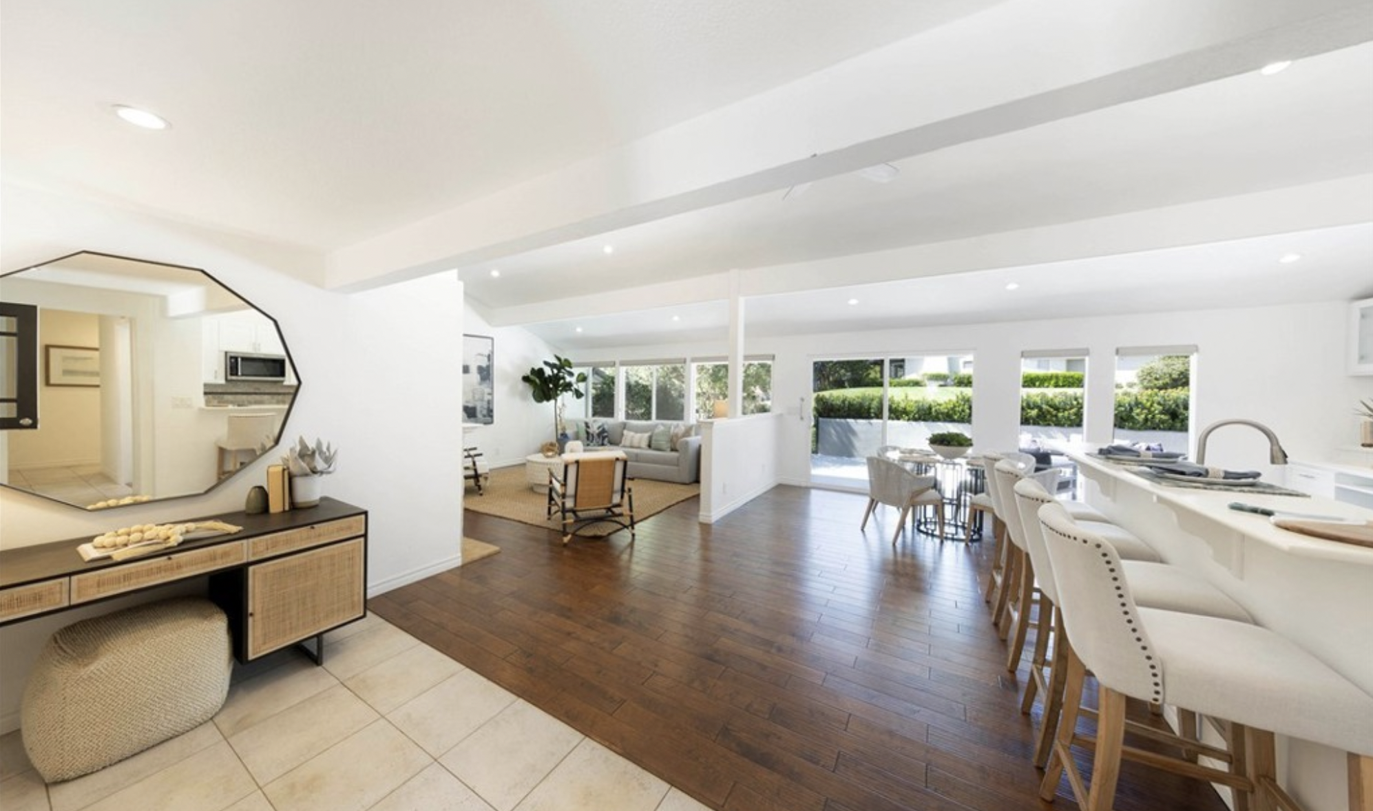 Bright open-concept Newport Beach home interior with white kitchen, breakfast bar, dining area, and living room, listed by Janice Arrigo and Patty Presson